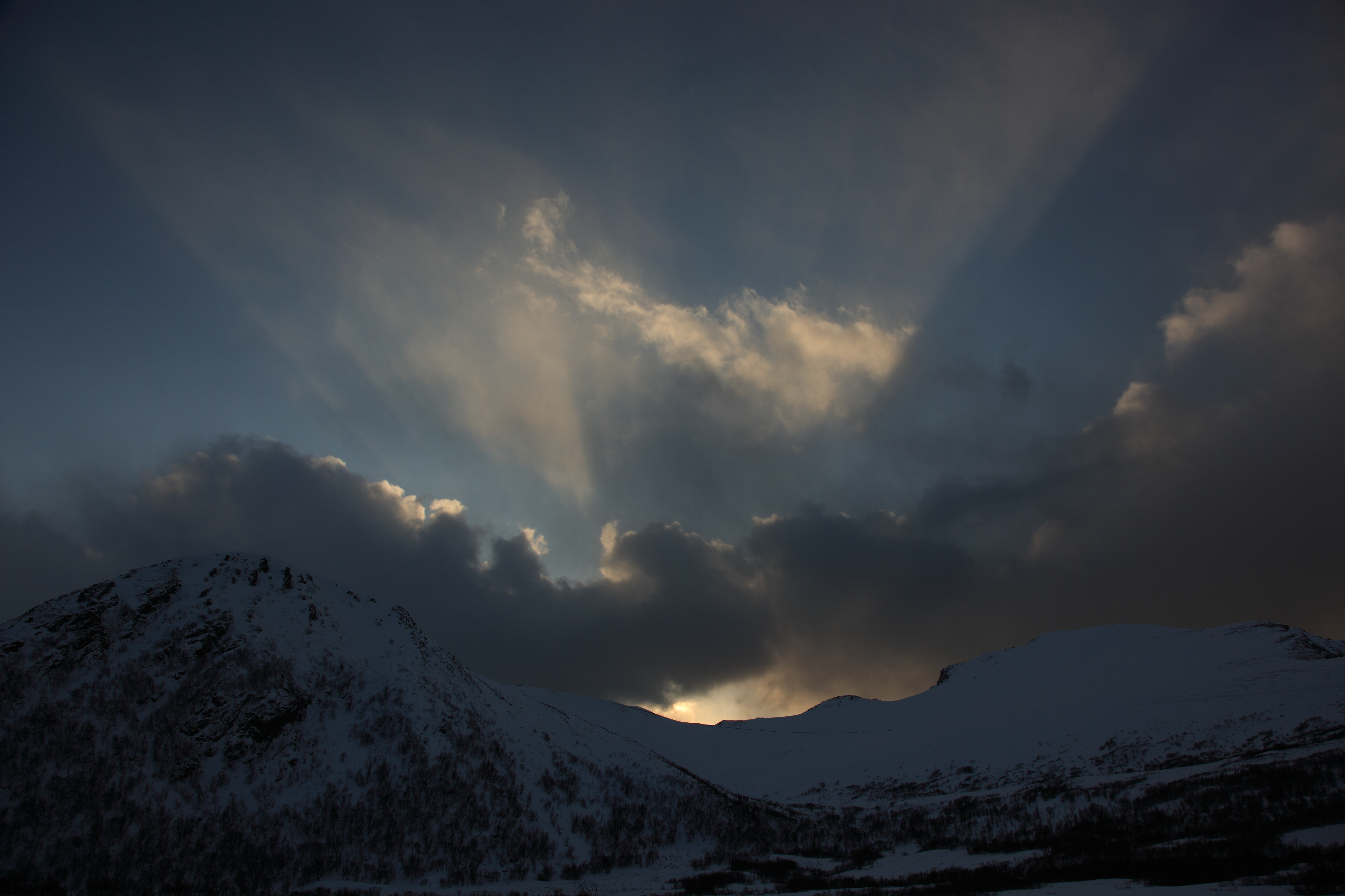 Fjell og skya kaste skygga fra ei sol som vil opp