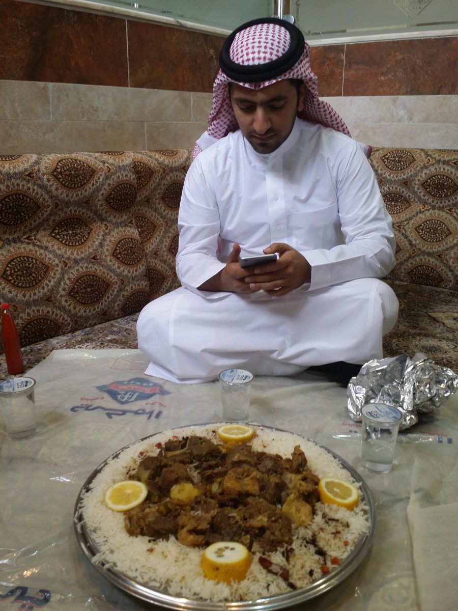 Prins Turki Al-Saud sin sekretær, og vårres guide og kontakt under heile besøket - her en siste SMS før stekt kamel og ris skal spises. På gulvet, selvfølgelig